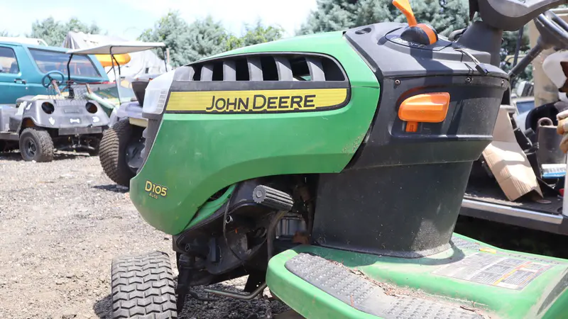 A John Deere riding mower in the yard