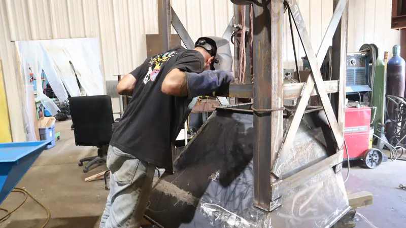 A fabricator fitting up a large steel frame in the shop