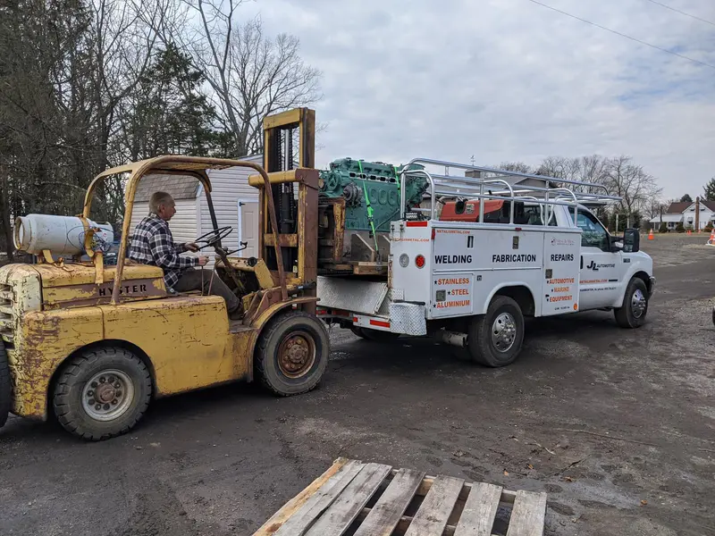 The shop forklift loading an engine onto the service truck