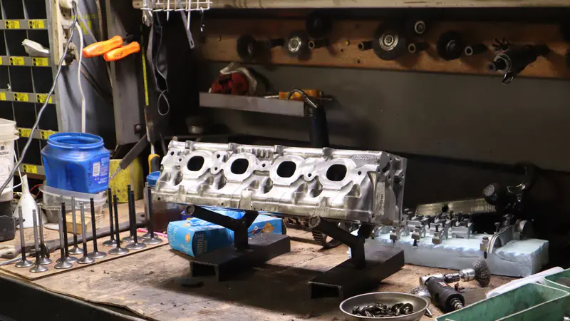 Cylinder heads and valves laid out on the machine shop bench