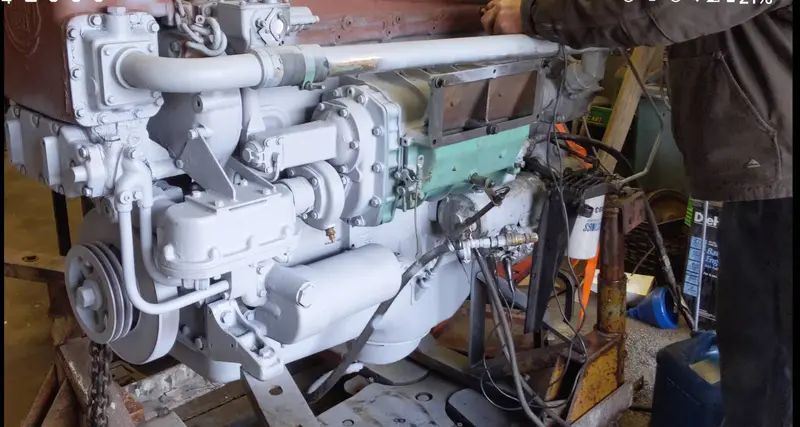 A white-painted marine engine on the shop floor, mid-service