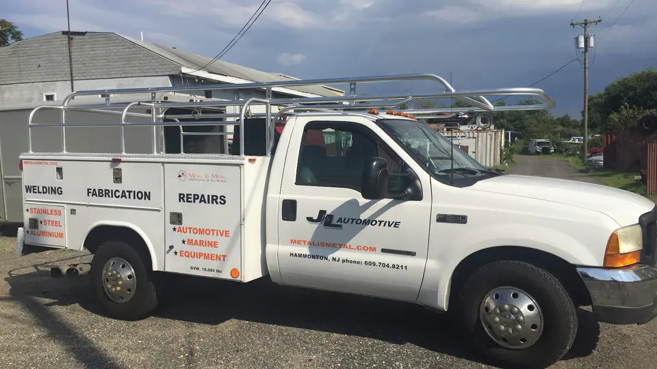 The shop’s white service truck with its polished aluminum ladder rack, lettered for welding, fabrication and repairs