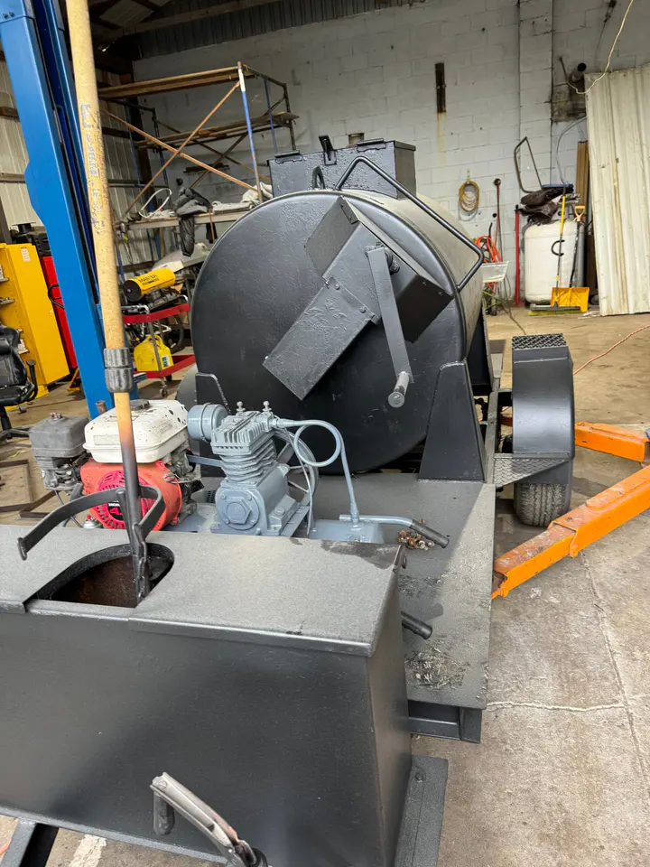 A custom tank trailer with its hatch open, in the shop