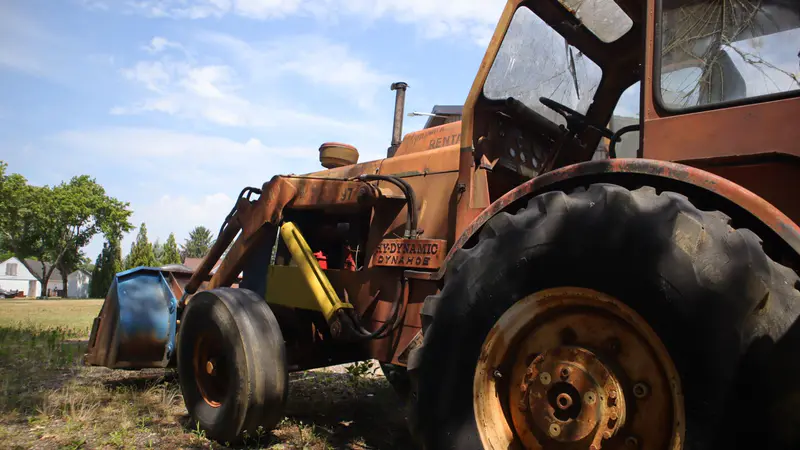 An old Dynahoe loader tractor sitting in the yard